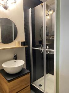 a bathroom with a glass shower and a sink at So Cosy in Bouguenais