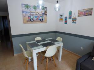 une table à manger avec des chaises et un tableau de bus sur le mur dans l'établissement Casa Julia - OASIS PAPAGAYO, à Corralejo