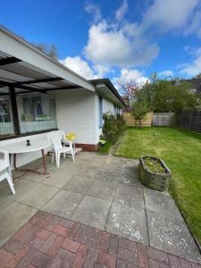a patio with a table and chairs in a yard at Badehausallee 20 Bungalow in Cuxhaven