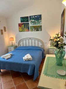 a bedroom with a blue bed with towels on it at CASA MAESTRALE - Vista mare Pittulongu - Sardegna - IUN R2217 in Olbia
