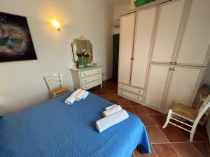 a bedroom with a blue bed with towels on it at CASA MAESTRALE - Vista mare Pittulongu - Sardegna - IUN R2217 in Olbia