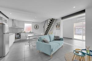 a living room with a blue couch and a kitchen at LA MEDITERRANEENNE in Quint-Fonsegrives