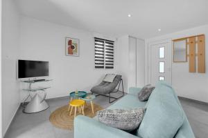 a living room with a blue couch and a tv at LA MEDITERRANEENNE in Quint-Fonsegrives