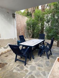 una mesa de picnic y 4 sillas en el patio en Domus de Mar, en Stintino