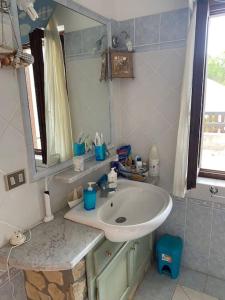 y baño con lavabo y espejo. en Domus de Mar, en Stintino