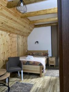 - une chambre avec un lit et une chaise dans l'établissement Sumski kutak, à Žabljak