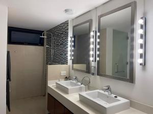La salle de bains est pourvue de 2 lavabos et d'un grand miroir. dans l'établissement New Appartement Fisherman, à Bophut 
