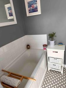 a bath tub in a bathroom with a tile floor at Cosy 19th century two bedroomed home with continental Breakfast in Bath