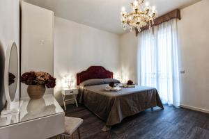 a bedroom with a bed and a chandelier at Sinfonia 23 in Ravenna