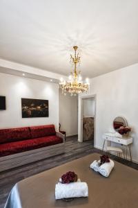 een woonkamer met een rode bank en een kroonluchter bij Sinfonia 23 in Ravenna