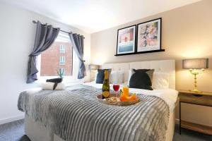 a bedroom with a bed with a tray of fruit on it at City Centre Apartment with Free Parking, Balcony, Super-Fast Wifi and Smart TV with Netflix by Yoko Property in Northampton