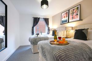 a hotel room with a bed with a tray of fruit at City Centre Apartment with Free Parking, Balcony, Super-Fast Wifi and Smart TV with Netflix by Yoko Property in Northampton