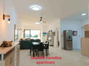 a kitchen and living room with a table and a refrigerator at Seaside Paradise 2 minutes à pied du Lagoon in Pereybere