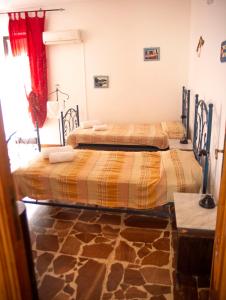 two beds in a room with a room with rocks at Calciufetta in Alghero