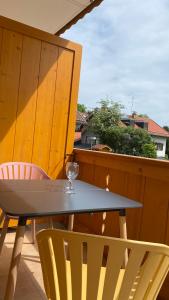 ein Glas Wein auf einem Tisch auf einem Balkon in der Unterkunft Anne am Kurpark in Bad Tölz