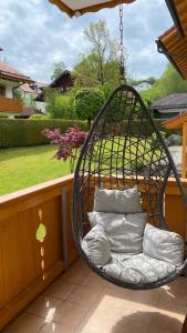 a hanging chair with pillows on a balcony at Anne am Kurpark in Bad Tölz