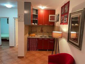 a kitchen with red cabinets and a red chair at Comfortable Villa Oliva in Čanj