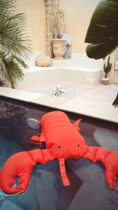 uma lagosta vermelha deitada numa piscina de água em La Maison du Trident en Camargue Piscine et Jacuzzi em Vauvert