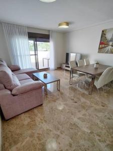 ein Wohnzimmer mit einem Sofa und einem Tisch in der Unterkunft Full apartment with private pool in Estepona