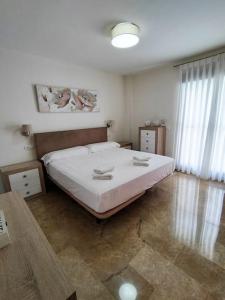 ein Schlafzimmer mit einem großen weißen Bett und einem Fenster in der Unterkunft Full apartment with private pool in Estepona