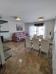 ein Wohnzimmer mit einem Tisch, Stühlen und einem Sofa in der Unterkunft Full apartment with private pool in Estepona