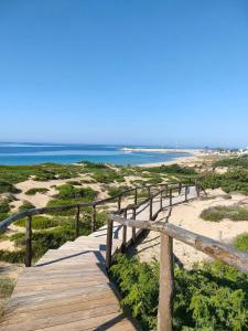 un paseo marítimo hasta la playa con el océano en el fondo en B&B Sole Mare Vento, en Maruggio