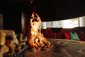 a fire is coming out of a fireplace at Thurntaler Rast in Außervillgraten