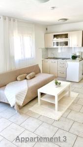 - un salon avec un canapé et une table dans l'établissement Croadriatic Apartments, à Vir