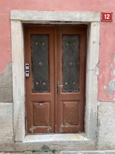 a brown door with two windows in a building at Tartini - private roof terrace - self check-in in Piran