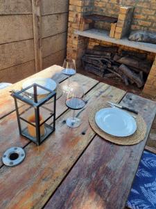 a wooden table with two glasses of wine on it at Riebeeck Cottage in Potchefstroom