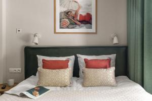 a bed with a green headboard and red pillows at Baltic Wave Boutique Apartments with sauna and gym in Sopot