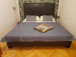 a bed with a blue comforter and a pillow on it at Two bells in Šibenik