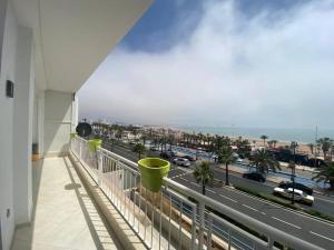 een balkon met uitzicht op een snelweg met auto's bij Lovely Seaview beachfront Apartment in Agadir