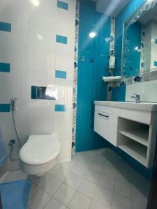 een blauwe en witte badkamer met een toilet en een wastafel bij Lovely Seaview beachfront Apartment in Agadir