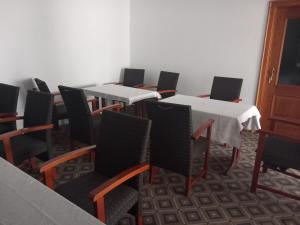 a row of tables and chairs in a room at Casa Marza in Ghioroc +47 photos