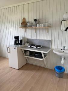 uma pequena cozinha com um balcão e um lavatório em Solvang Ferietun em Vangsnes