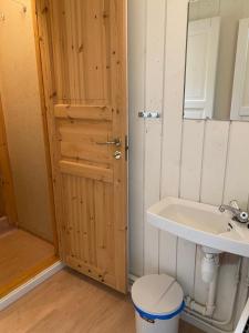 a bathroom with a sink and a toilet and a door at Solvang Ferietun in Vangsnes