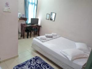 1 dormitorio con 1 cama y escritorio con ordenador en Hotel Ikhwan Tanjung Malim, en Tanjung Malim