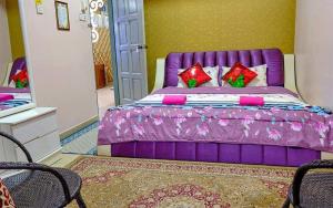 Cama morada en una habitación con espejo en Hotel Ikhwan Tanjung Malim, en Tanjung Malim