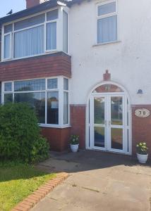 a white house with a white door and windows at B&B No. 70 in Southport