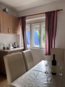 a kitchen with a table with a bottle of wine on it at Apartments Radulovic in Sutomore