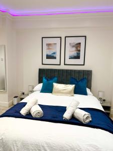 a bedroom with a large white bed with blue pillows at London Charm - Stylish Studio in Kensington in London