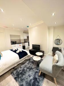 a bedroom with a bed and a couch and a chair at London Charm - Stylish Studio in Kensington in London