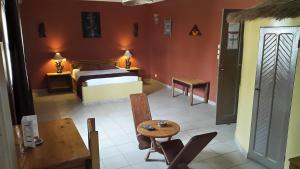 Zimmer mit einem Schlafzimmer mit einem Bett und einem Tisch in der Unterkunft Maison d'hôtes Opanoramic in Dakar