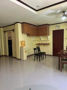 a kitchen with chairs and a table and a refrigerator at Jimsville executive homes in Liloan