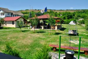 einen Hof mit einem Park mit einer Bank und einem Haus in der Unterkunft La foisor in Turda