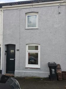 a gray house with a black door and a trash can at Hopefield in Newport