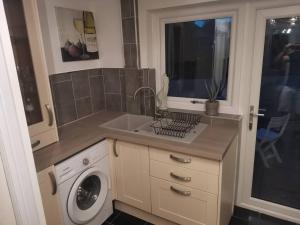 a kitchen with a sink and a washing machine at Hopefield in Newport
