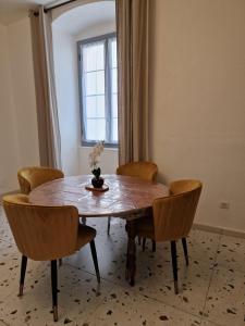 a dining room table with chairs and a vase on it at Laetitia in Bastia