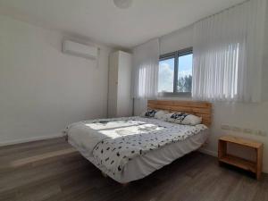 sypialnia z dużym łóżkiem i oknem w obiekcie Golden beach cottage by the sea w mieście Cezarea